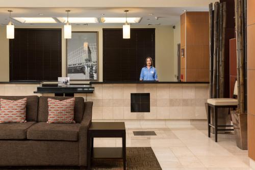 a woman standing behind a counter in a lobby at Staybridge Suites Las Vegas - Stadium District in Las Vegas