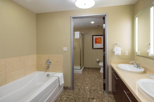 a bathroom with a tub and two sinks and a toilet at Staybridge Suites Las Vegas - Stadium District in Las Vegas