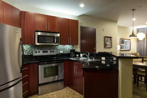 a kitchen with a stove and a microwave at Staybridge Suites Las Vegas - Stadium District in Las Vegas