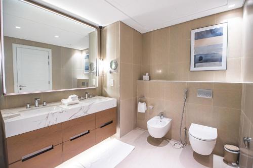 a bathroom with a sink and a toilet and a mirror at Luxurious 3 bedroom apartment with beach and pool access in Fujairah