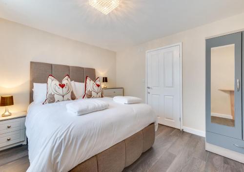 a bedroom with a large bed and a tv at Ardley Cottage Squirrel in Waldingfield