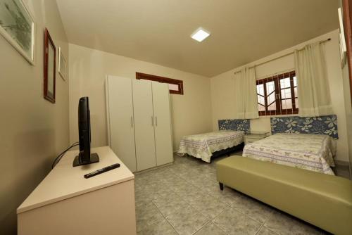 a living room with two beds and a television at Apartamento Vera in Florianópolis