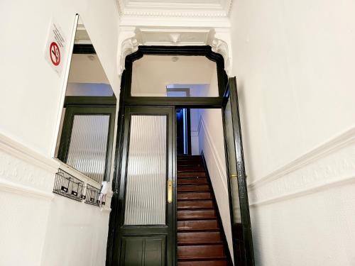 een hal met een groene deur in een gebouw bij Chambre privée au 3e étage sans ascenceur en plein centre de Charleroi in Charleroi