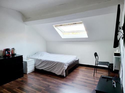 een slaapkamer met een bed en een dakraam bij Chambre privée au 3e étage sans ascenceur en plein centre de Charleroi in Charleroi
