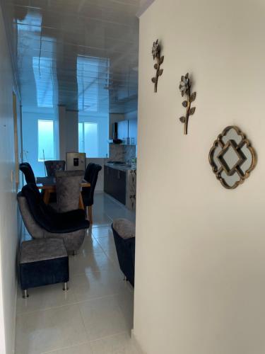 a living room with a table and chairs and a wall at Hermoso apartamento en Barbosa Santander in Barbosa