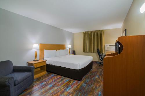 um quarto de hotel com uma cama e uma cadeira em Americas Best Value Inn Fargo em Fargo
