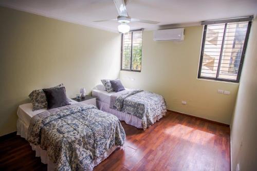 1 dormitorio con 2 camas y 2 ventanas en Amplio apartamento en zona exclusiva con parqueo, en Los Prados