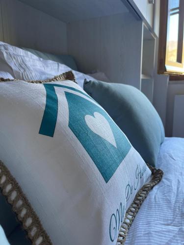 a bed with a blue and white pillow on it at Ma. De House Lago del Turano in Valle Verde