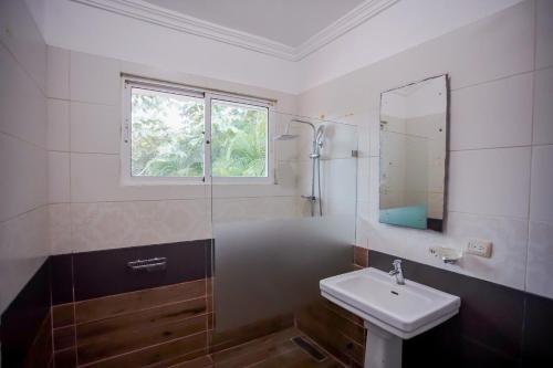 y baño con lavabo, ducha y espejo. en Impresionante villa con piscina Metro Country Club, en Paraíso