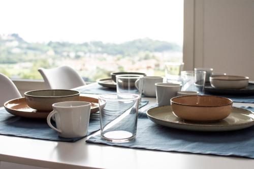 una mesa con platos, tazones y vasos. en Casa Vittoria Guest House, en Romano D'Ezzelino