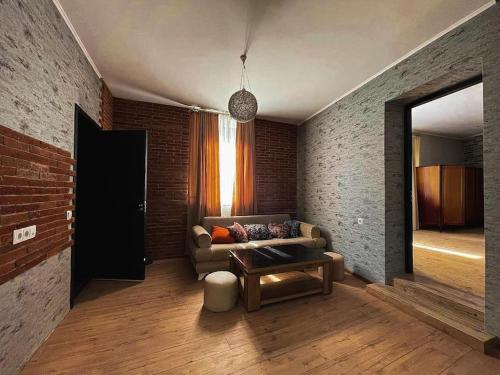 提比里斯的住宿－Sioni Apartment，带沙发和砖墙的客厅