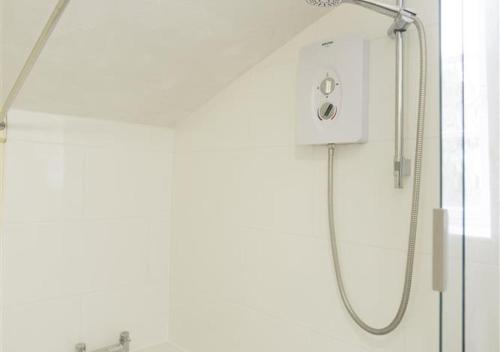 a shower with a shower head in a bathroom at Rose Cottage in Bealings