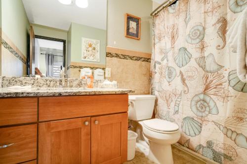 a bathroom with a toilet and a shower curtain at Sand & Sea: Rare Ruby (218) in Seaside