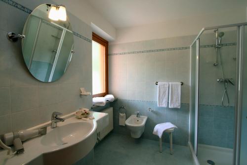 a bathroom with a sink and a toilet and a mirror at Hotel Dama Bianca in Valtournenche
