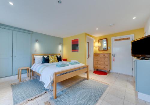 a bedroom with a large bed and a tv at Shoreline in Aldeburgh