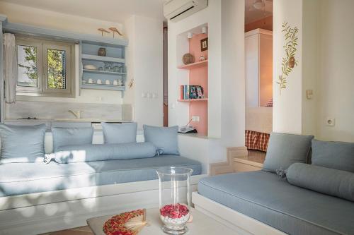 a living room with blue couches and a window at Roi Boutique Suites in Asos