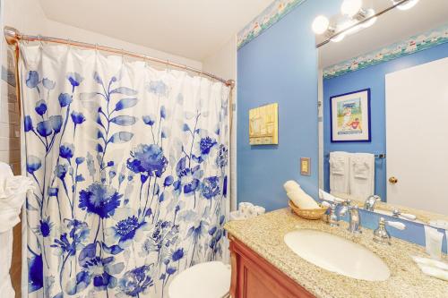 baño con cortina de ducha azul y blanco y lavamanos en Ocean Mandevilla, en Brewster