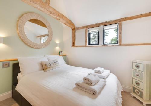a bedroom with a white bed with towels on it at The Byre in Bramfield