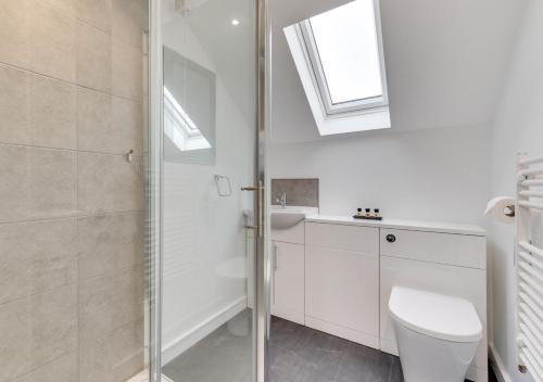 La salle de bains blanche est pourvue de toilettes et d'un lavabo. dans l'établissement Ardley Cottage Badger, à Waldingfield
