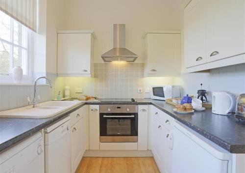 a kitchen with white cabinets and a sink and a stove at Garden View in Parham