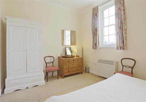 a bedroom with a bed and two chairs and a dresser at Garden View in Parham