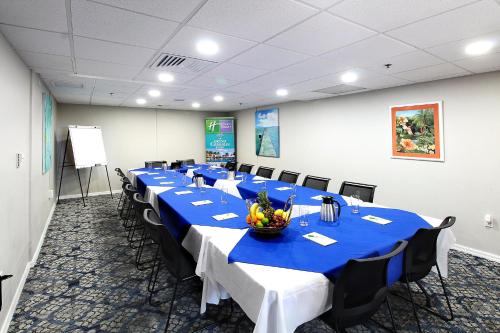 a conference room with a long table with blue tables and chairs at Holiday Inn Resort Grand Cayman by IHG in George Town