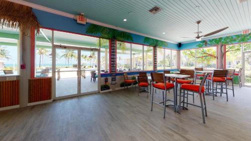 a restaurant with tables and chairs and windows at Holiday Inn Resort Grand Cayman by IHG in George Town