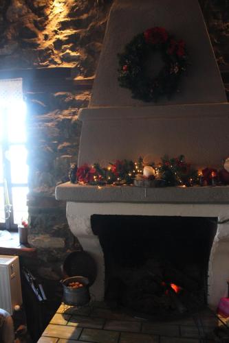 a fireplace with christmas decorations on top of it at Feggaropetra Inn Magic Mountain House in Palaios Panteleimon