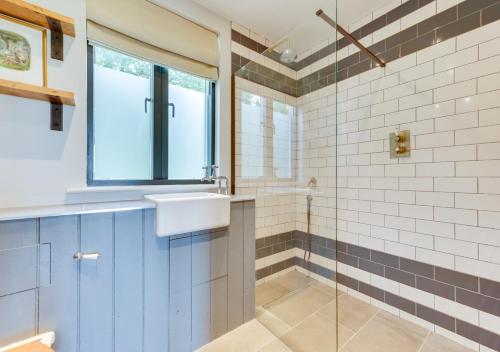 a bathroom with a sink and a glass shower at The Old School House in Wickhambrook