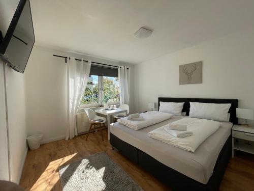 Un dormitorio con una cama con un escritorio y una ventana. en DEICHHÜTTE NORDDEICH, en Norddeich