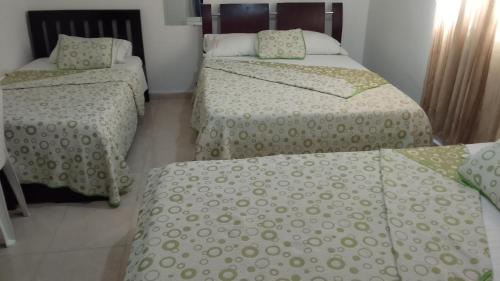 um quarto com duas camas e duas camas individuais em Hotel La Leyenda Vallenata em Valledupar