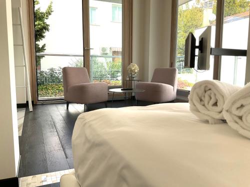 una camera con un letto e due sedie e finestre di Grand Apartment Sissi a Trieste