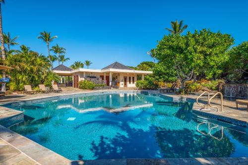 a swimming pool in front of a house at Mauna Lani Point in Waikoloa