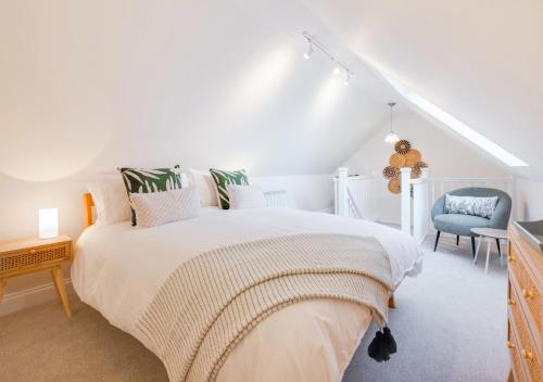 Lux Lodge في Playford: غرفة نوم بيضاء بسرير وكرسي