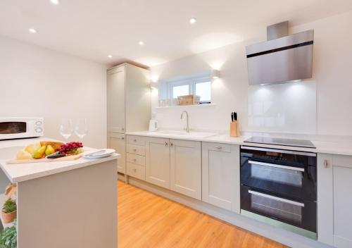 a white kitchen with a sink and a stove top oven at Lux Lodge in Playford