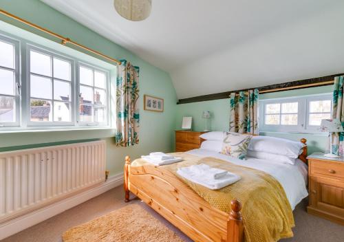 a bedroom with a bed and a large window at Corner Cottage in Wangford