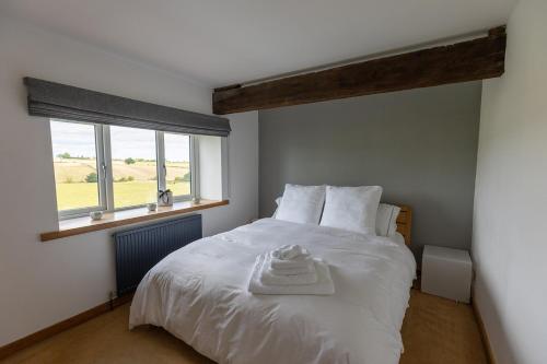 a bedroom with a white bed with a window at BIRDS EDGE COTTAGE - Luxury 2 Bedroom Cottage with Amazing Views, Near Holmfirth in Yorkshire in Denby Dale