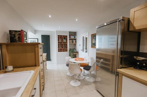 uma cozinha com um lavatório e uma mesa com cadeiras em BIRDS EDGE COTTAGE - Luxury 2 Bedroom Cottage with Amazing Views, Near Holmfirth in Yorkshire em Denby Dale