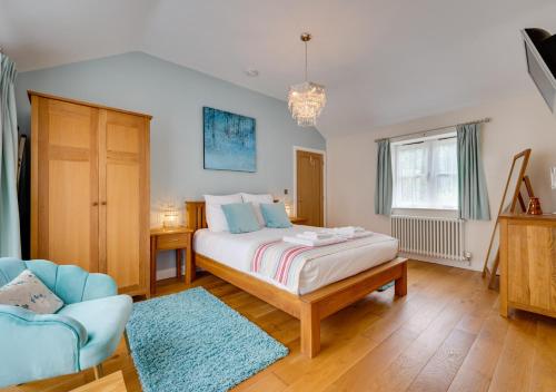 a bedroom with a bed and a couch and a chair at Woodland Lodge in Wilby