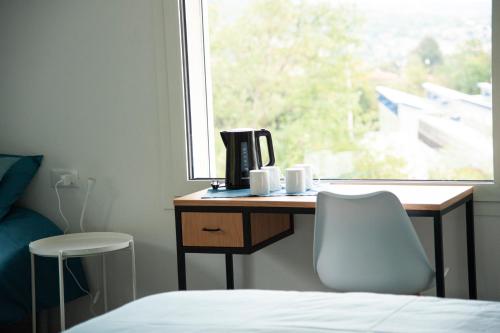 a bedroom with a bed and a desk and a window at Casa Vittoria Guest House in Romano D'Ezzelino
