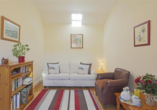 a living room with a couch and a chair at The Cartshed in Wangford