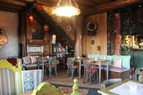 a restaurant with tables and chairs and a chandelier at Feggaropetra Inn Magic Mountain House in Palaios Panteleimon