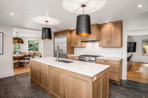 a kitchen with wooden cabinets and white counter tops at Modern Beaver Creek Private House! in Avon