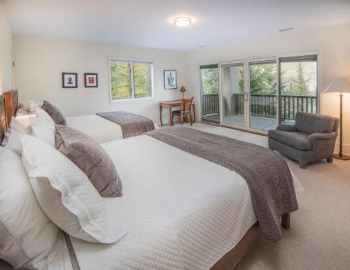 two beds in a bedroom with a balcony at Modern Beaver Creek Private House! in Avon