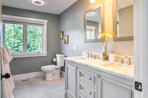 a bathroom with a sink and a toilet and a mirror at Pet-Friendly Minneapolis Home about 6 Mi to Dtwn! in Minneapolis