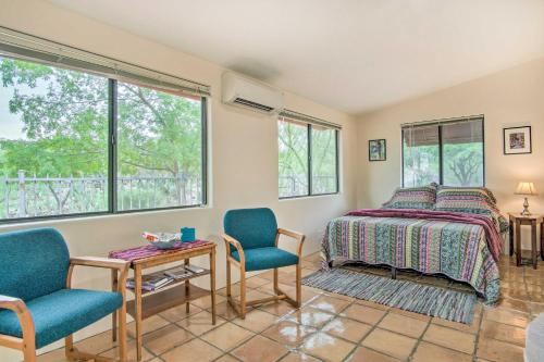 a bedroom with a bed and two chairs and a table at Charming Tucson Casita Near Hiking and Biking! in Tucson