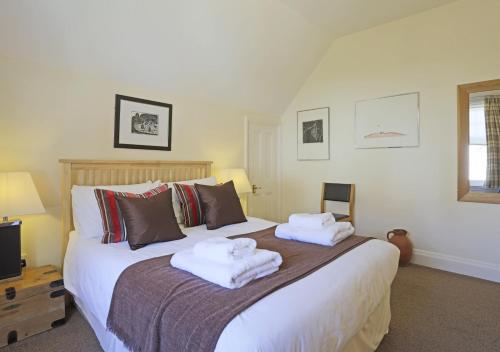 a bedroom with a large bed with towels on it at Far View Two in Southwold