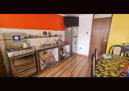 a kitchen with a stove and a sink and a table at Hospedaje apus in Huaraz