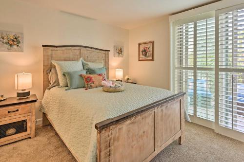 a bedroom with a large wooden bed with pillows at Breezy Oceanside Condo Less Than half Mi to Beach! in Oceanside
