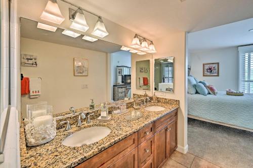 a bathroom with two sinks and a bedroom at Breezy Oceanside Condo Less Than half Mi to Beach! in Oceanside